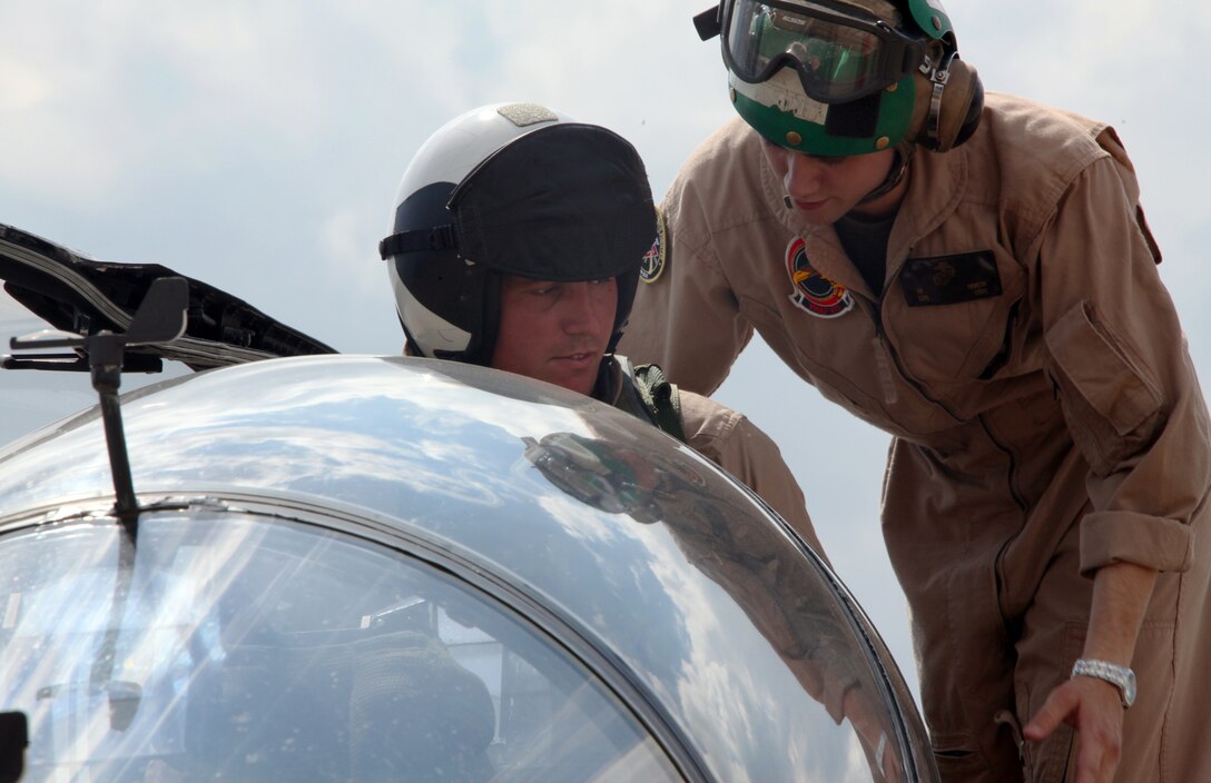 Medal of Honor recipient Sgt. Dakota L. Meyer is briefed on cockpit emergency procedures and controls for the T/AV-8B Harrier by Lance Cpl. Jacob M. Heaton, an ejection seat mechanic with Marine Attack Training Squadron 203 April 20, aboard Kentucky Air National Guard Base, prior to Meyer’s flight during the Thunder Over Louisville air show April 21. Marine Attack Training Squadron 203, based at Marine Corps Air Station Cherry Point, provided the harrier for the flight. “This is my first time ever flying in a harrier, but I’ve seen Top Gun about a dozen times,” said Meyer. “If Tom Cruise can handle flying a jet then I can too. I just hope I don’t throw-up.”