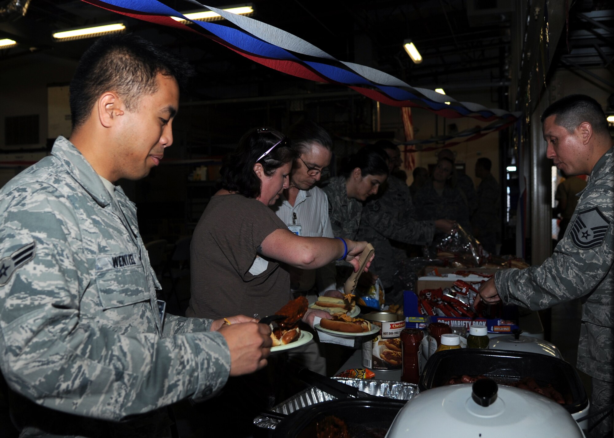 ALTUS AIR FORCE BASE, Okla. -- Airman 1st Class Don Wentzel, 97th Medical Group bioenvironmental engineering technician, fills his plate with food at the 97th MDG warehouse April 20, 2012. The 97th MDG organized a gathering to recognize their people for 23 DUI-free years. (U.S. Air Force Photo by Airman Klynne Pearl Serrano / 97th Air Mobility Wing Public Affairs / Released)