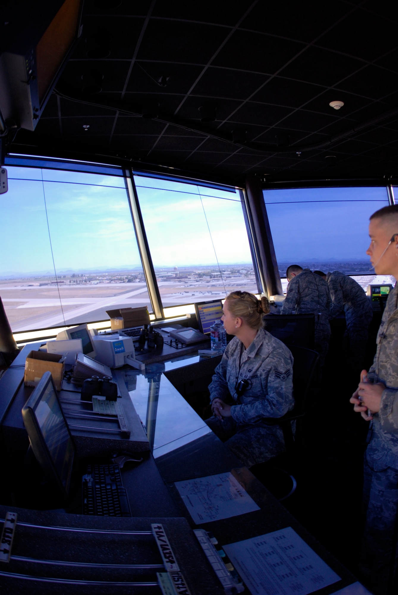 Senior Airman Nicole Hess and Airman 1st Class Matt Goodspeed, 56th Operations Support Squadron air traffic controllers, look toward the north end-of-runway as they clear a jet for takeoff.  The tower maintains control of all aircraft within a 5-mile radius of the base as well as all ground movement on the airfield.  (U.S. Air Force photo by Senior Airman CJ Hatch)