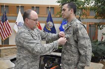 Air Force Lt. Col. Mike Rakoczy, Air Force Mortuary Affairs Operations deputy commander, presents Capt. Donald D. Johnson III, AFMAO commander’s action group, the Bronze Star during a ceremony April 20, 2012 in the atrium of the Charles C. Carson Center for Mortuary Affairs. Johnson was awarded the Bronze Star for his year of service in Afghanistan. (U.S. Air Force photo/Staff Sgt. James W. Jackson) 