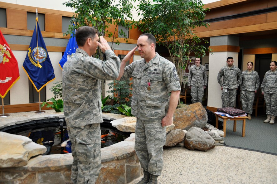 Chief Master Sgt. David Fish, Air Force Mortuary Affairs Operations chief enlisted manager, salutes Col. Thomas C. Joyce, AFMAO commander, during a medal presentation April 17, 2012 at the Charles C. Carson Center for Mortuary Affairs. Fish was awarded the Meritorious Service Medal, fourth oak leaf cluster, during a commander’s call. (U.S. Air Force photo/Tech. Sgt. Myco Apat)