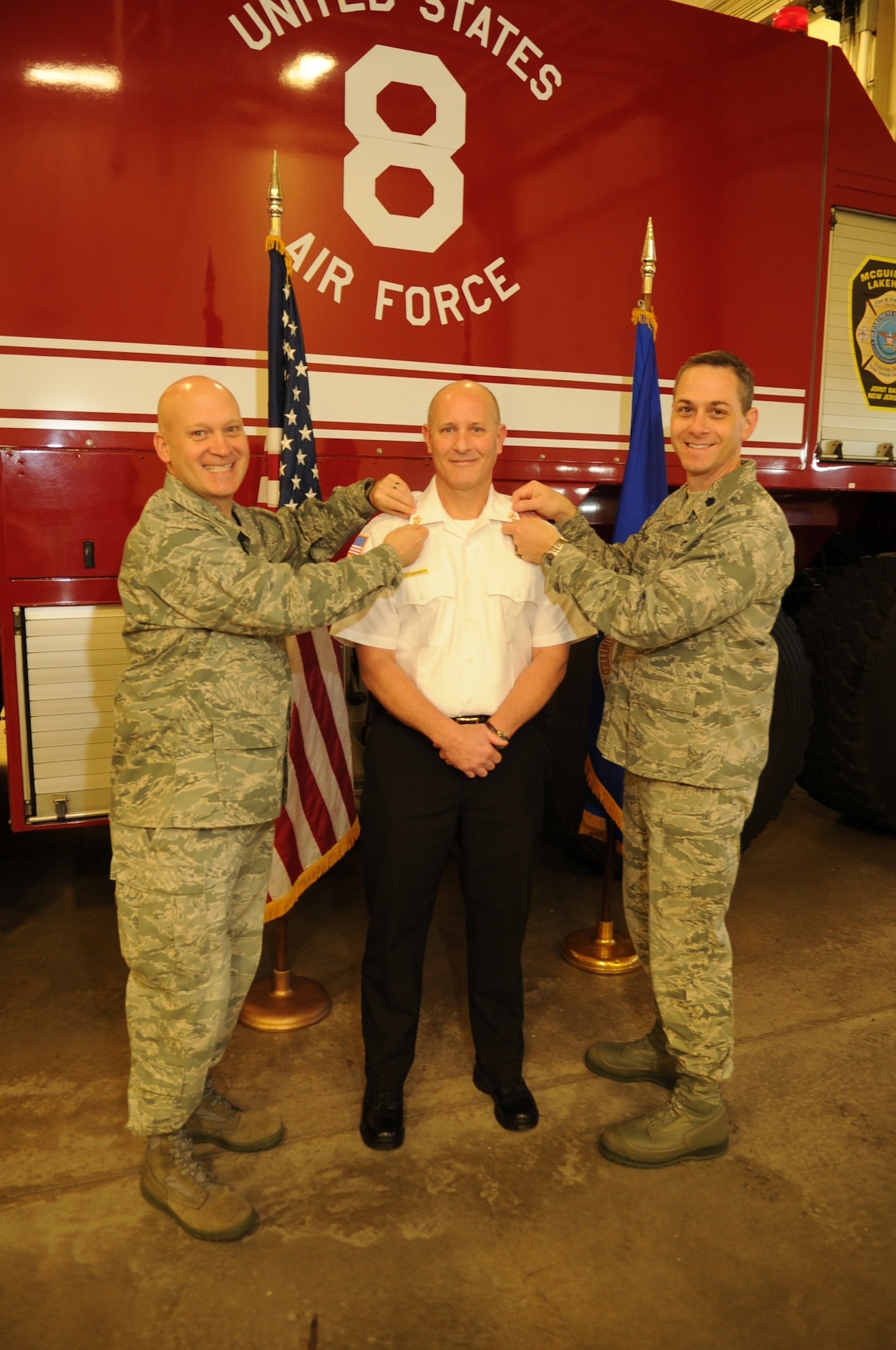 Colonel Chris Luedke, 87th Mission Support Group commander, and Lt. Col. Charles Kuhl, 87th Civil Engineer Squadron commander, pinned on Thomas Nicometi’s chief’s badge and bugle during a promotion ceremony April 6 here. Nicometi has been a firefighter for the past 32 years and is the first civilian fire chief at Joint Base McGuire-Dix-Lakehurst in more than 12 years. (U.S. Air Force Courtesy Photo/Released)
