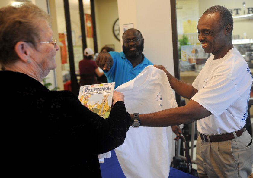 Bill Fowler gives Carolyn Watson an Earth Day t-shirt at Moody Air Force Base, Ga., April 19, 2012. Fowler gave Moody members ecologically friendly trinkets and informational handouts to help spread awareness and appreciation of the Earth's natural resources and environment. (U.S. Air Force photo by Airman 1st Class Douglas Ellis/Released)
