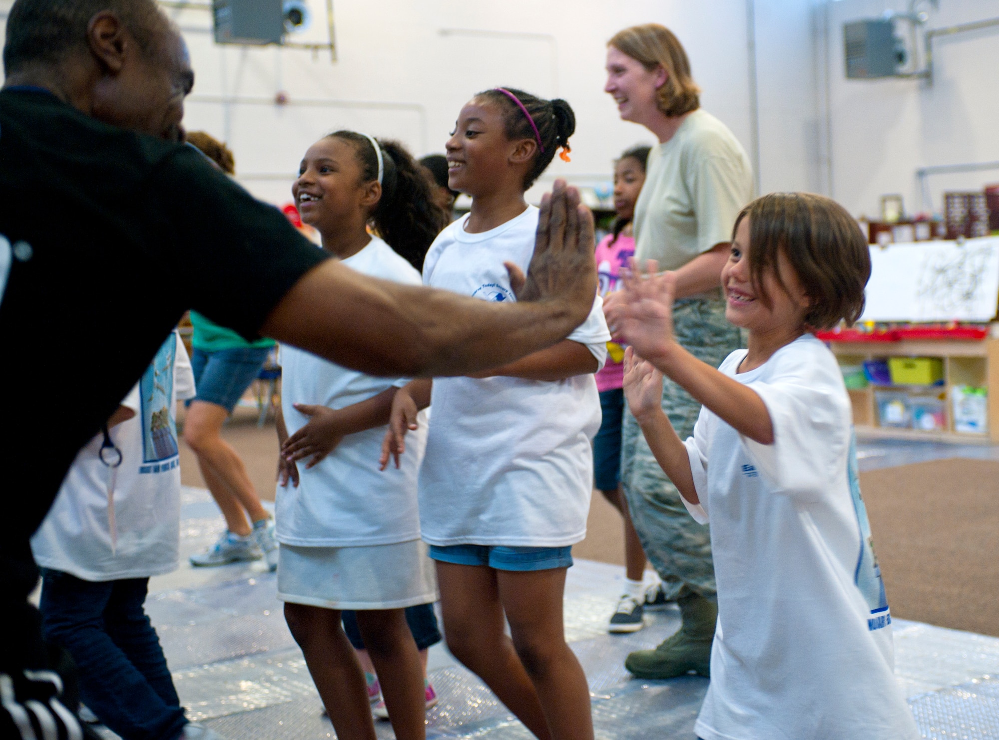 Madison Carr, daughter of Staff Sgt. Ryan Carr, high-fives Bill Fowler, 23d Civil Engineer Squadron environmental compliance supervisor, during a Zumba session April 18, 2012, at the youth center on Moody Air Force Base, Ga. Moody held a number of events for Earth Week, including presentations at the youth and Child Development Center as well as an information booth in the Base Exchange. (U.S. Air Force photo by Airman 1st Class Jarrod Grammel/Released)
