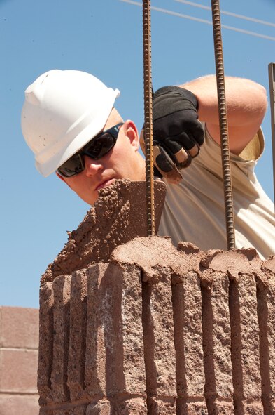 HOLLOMAN AIR FORCE BASE, N.M. – Senior Airman Kelley Hutto, 49th Civil Engineer Squadron stuctures apprentice, lays cement between bricks on a restroom for the outdoor sports complex April 16. The 49th CES has teams of Airmen who build structures all over Holloman AFB. (U.S. Air Force photo by Airman Leah Ferrante/Released)
