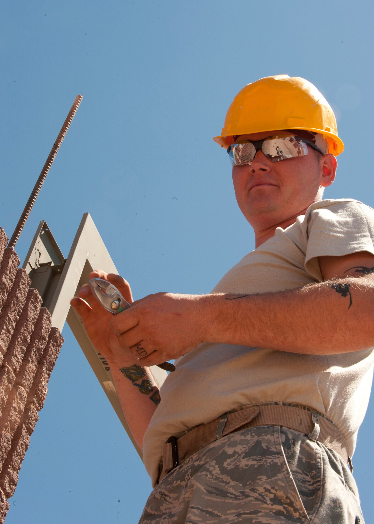 HOLLOMAN AIR FORCE BASE, N.M. – Staff  Sgt. Joseph Hosak, 49th  Civil Engineer Squadron structures craftsman, waits for another Airman to hand him a tool April 16. Hosak and his fellow 49th CES structures Airmen regularly lay bricks for structures around Holloman AFB. Currently, they are building a restroom for the outdoor sports complex. (U.S. Air Force photo by Airman Leah Ferrante/Released)