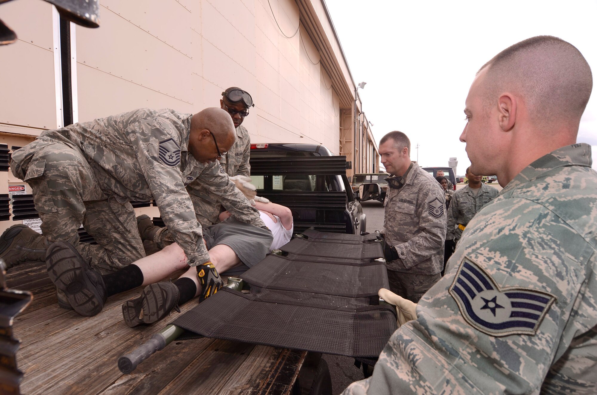 94th Aeromedical Staging Squadron personnel work to get a newly arrived patient properly secured on a stretcher and into the Contingency Aeromedical Staging Facility, during a mass casualty exercise at Dobbins Air Reserve Base, Ga., Apr. 15.  The exercise tested the ability of the Georgia State Defense Force to work with 94th Airlift Wing military personnel in treating and evacuating natural disaster victims from the Atlanta area.  (U.S. Air Force photo/ Brad Fallin)