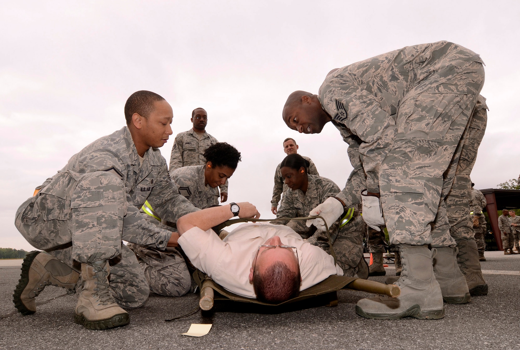 94th Aeromedical Staging Squadron personnel work to get a newly arrived patient properly secured on a stretcher and into the Contingency Aeromedical Staging Facility, during a mass casualty exercise at Dobbins Air Reserve Base, Ga., Apr. 15.  The exercise tested the ability of the Georgia State Defense Force to work with 94th Airlift Wing military personnel in treating and evacuating natural disaster victims from the Atlanta area.  (U.S. Air Force photo/ Brad Fallin)