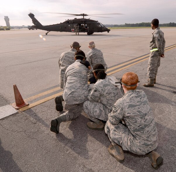 94th Aeromedical Staging Squadron personnel wait for the signal to approach the Georgia Army National Guard helicopter and off-load another patient arriving at the Contingency Aeromedical Staging Facility, during a mass casualty exercise at Dobbins Air Reserve Base, Ga., Apr. 15.  The exercise tested the ability of the Georgia State Defense Force to work with 94th Airlift Wing military personnel in treating and evacuating natural disaster victims from the Atlanta area.  (U.S. Air Force photo/ Brad Fallin)
