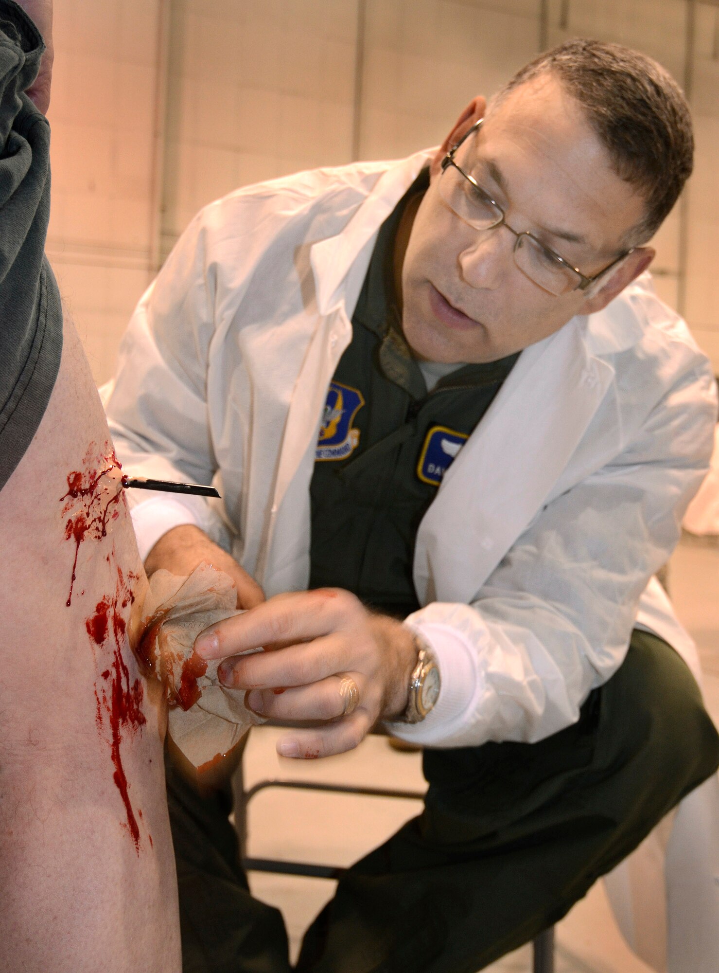 Lt. Col David Rodberg, 94th Aeromedical Evacuation Squadron, applies the finishing touches of blood on a wound he created on a role-playing victim in preparation for a mass casualty exercise at Dobbins Air Reserve Base, Ga., Apr. 15.  The exercise tested the ability of the Georgia State Defense Force to work with 94th Airlift Wing military personnel in treating and evacuating natural disaster victims from the Atlanta area.  (U.S. Air Force photo/ Brad Fallin)