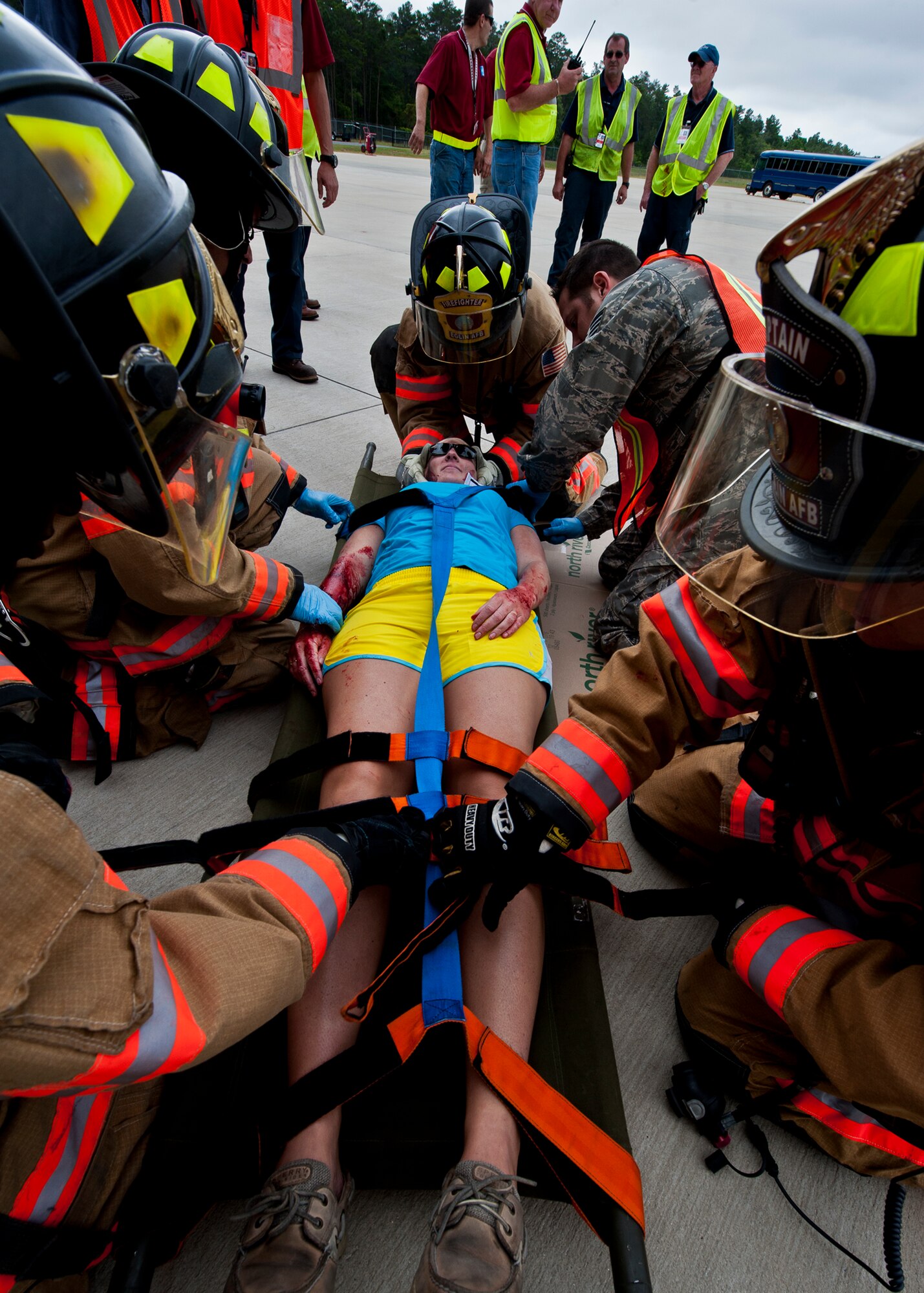 Sarah Massengill, a victim of a simulated aircraft fire is secured before emergency responders move her to the triage area during a mass casualty exercise at the Northwest Florida Regional Airport April 19.  The scenario called for emergency units from Eglin, Okaloosa County and the airport to respond to an aircraft on fire containing more than 40 passengers.  Response, communication and accountability were among many procedures under evaluation at the exercise.  Inside the airport, employees were tested on their response to an influx of friends and family members looking for information about the accident.  The Federal Aviation Administration mandates this type of major accident exercise execution every three years.  (U.S. Air Force photo/Samuel King Jr.)