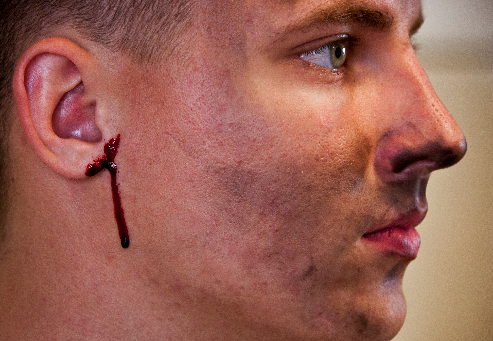 A ‘victim’ waits for more gore to be applied to his face and body prior to a mass casualty exercise April 19. The 96th Medical Group moulage team turned more than 40 volunteers into ‘horror movie’ realistic victims of an aircraft fire.  The team’s “art” provides a sense of realism in exercises that medics and first responders may encounter in real-world accidents.  (U.S. Air Force photo/Samuel King Jr.)