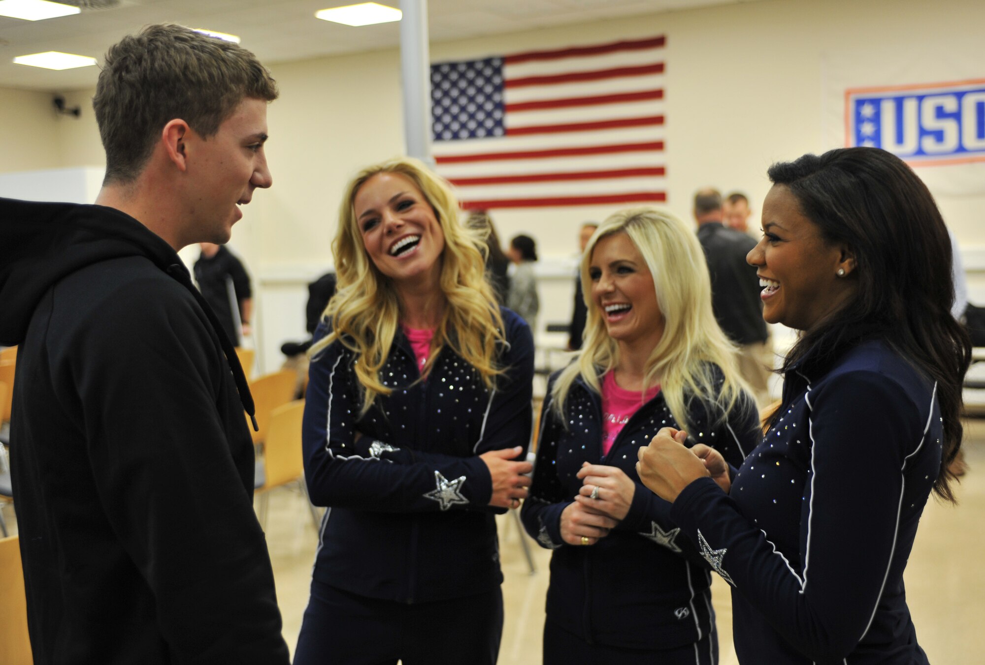 Navy Operations Specialist 2nd Class James Westrich meets with Dallas Cowboys Cheerleaders at the Contingency Aeromedical Staging Facility on Ramstein Air Base, Germany, April 20, 2012. During the United Services Organization and Armed Forces Entertainment tour, the ninth Vice Chairman of the Joint Chiefs of Staff, joined with a cast of entertainers, visited with troops stationed overseas. The tour consisted of live performances, and the group visited different organizations throughout the Kaiserslautern Military Community. (U.S. Air Force photo/Airman 1st Class Caitlin 
