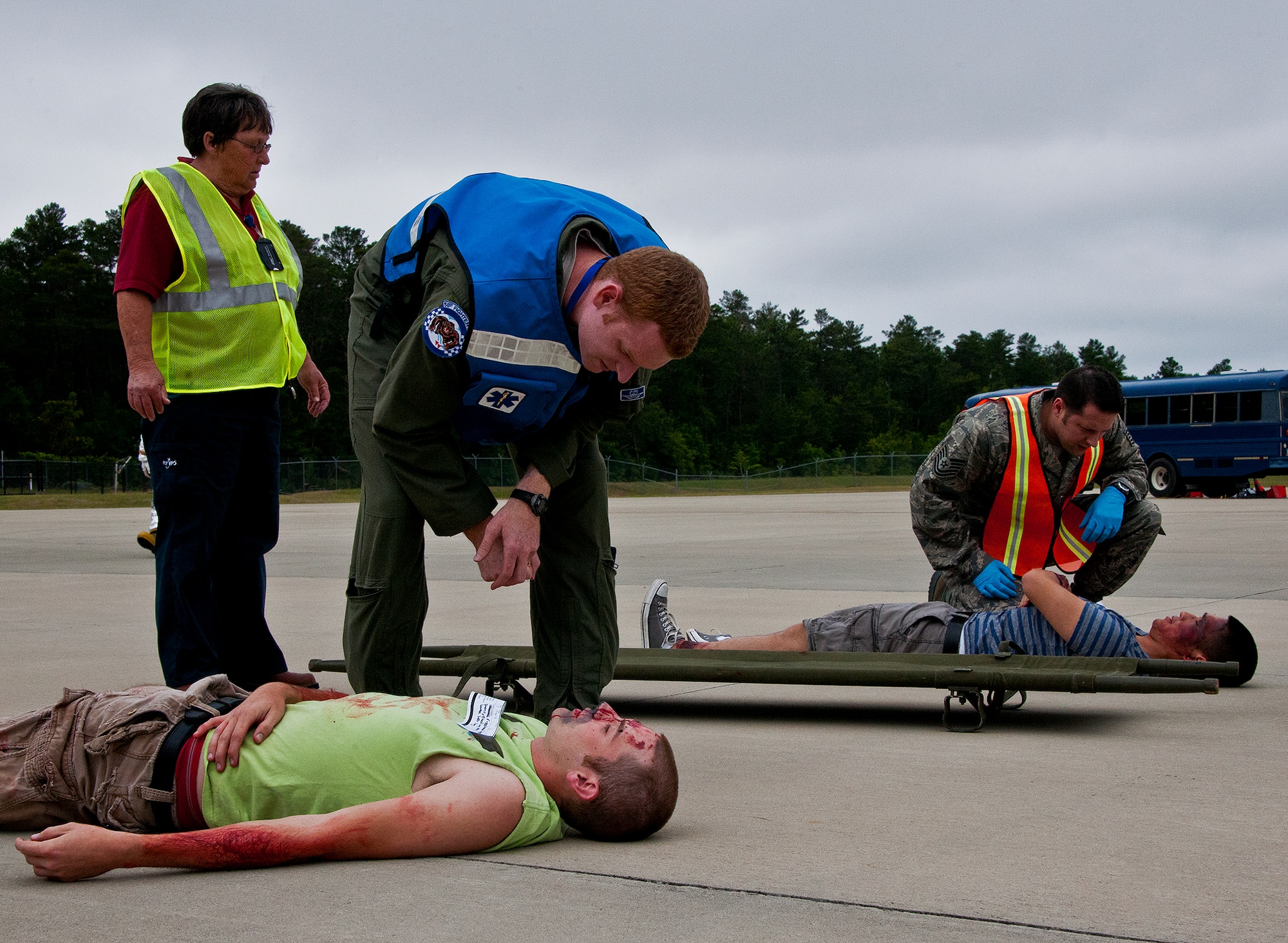 Capt. Casey Smith and Tech. Sgt. Matthew Scott, emergency medics from Eglin, evaluate victims of a simulated aircraft fire before directing them to the triage area, during a mass casualty exercise at the Northwest Florida Regional Airport April 19.  The scenario called for emergency units from Eglin, Okaloosa County and the airport to respond to an aircraft on fire containing more than 40 passengers.  Response, communication and accountability were among many procedures under evaluation at the exercise.  Inside the airport, employees were tested on their response to an influx of friends and family members looking for information about the accident.  The Federal Aviation Administration mandates this type of major accident exercise execution every three years.  (U.S. Air Force photo/Samuel King Jr.)