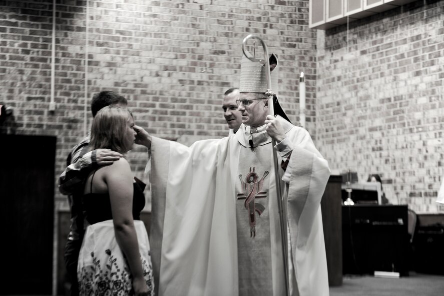 Archbishop Timothy Broglio, Archdiocese for Military Services, USA, anoints Rebekah Knight during Confirmation Mass at Moody Air Force Base, Ga., April 16, 2012. Individuals from Moody took part in the confirmation ceremony to continue their religious journey. (U.S. Air Force Photo by Airman 1st Class Paul Francis/Released)
