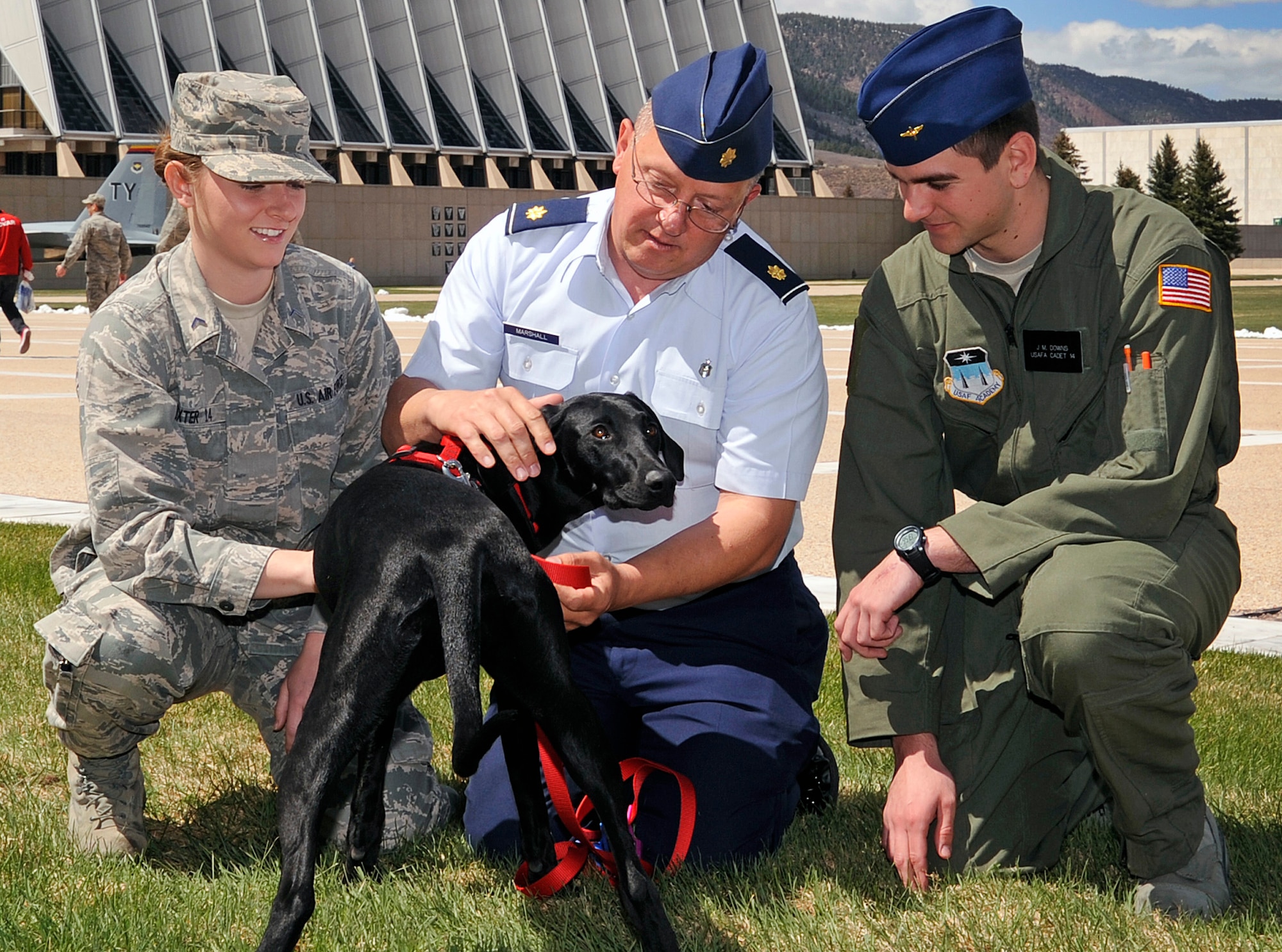 From left: Cadet 3rd Class Mercedes Dexter, Maj. Nicholas Marshall and Cadet 3rd Class J. Downs pose with Lulu, an 8-month-old therapy dog, in the Air Force Academy Terrazzo April 16, 2012. Marshall is Lulu's owner and the director of the Academy's Peak Performance Center, which provides cadets with therapy for life stresses like homesickness, test anxiety or relationship issues. Dexter is assigned to Cadet Squadron 32, and Downs is assigned to CS 40. (U.S. Air Force photo/Sarah Chambers)