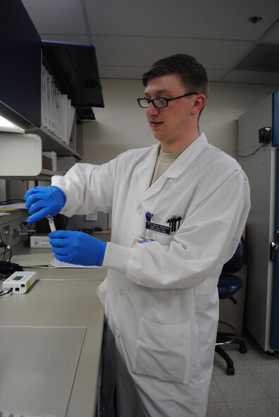 Senior Airman Sean Gleason, 341st MDSS lab technician, examines a liquid while pouring it into another test tube. Lab technicians are required to follow meticulous procedures to ensure results are 100 percent accurate. (U.S. Air Force photo/Airman 1st Class Katrina Heikkinen) 
