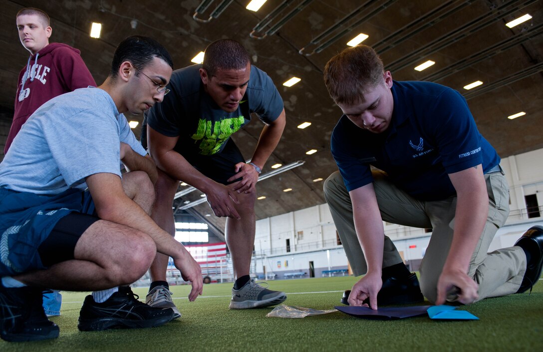 Airman 1st Class Luke Russel, 28th Force Support Squadron fitness specialist, reads a bonus question to Team Ballin during the Amazing Race event at Ellsworth Air Force Base, S.D., April 13, 2012 to give players a chance to shave minutes off their finish time. Teams that answered correctly were able to cut their event times which helped shorten the gap in the competition. (U.S. Air Force photo by Airman 1st Class Zachary Hada/Released)