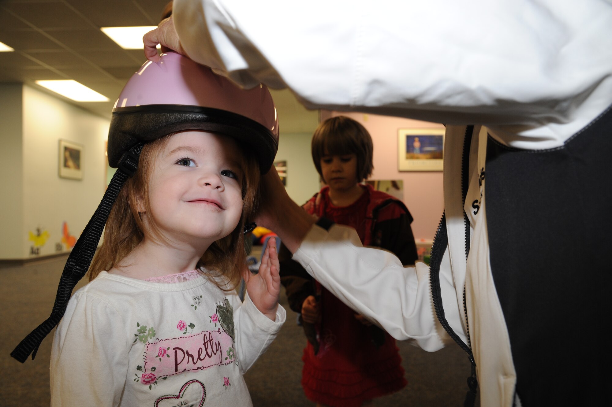 Kaylynn Morgan, daughter of Master Sgt. Ross Morgan of the 319th Security Forces Squadron, gets fitted for a bike helmet April 18, 2012, on Grand Forks Air Force Base, N.D.  Safe Kids is a nationwide network of organizations working to prevent unintentional childhood injury which is the leading cause of death and disability for children ages 1 to 14. (U.S. Air Force photo by Senior Airman Amber Bennett)