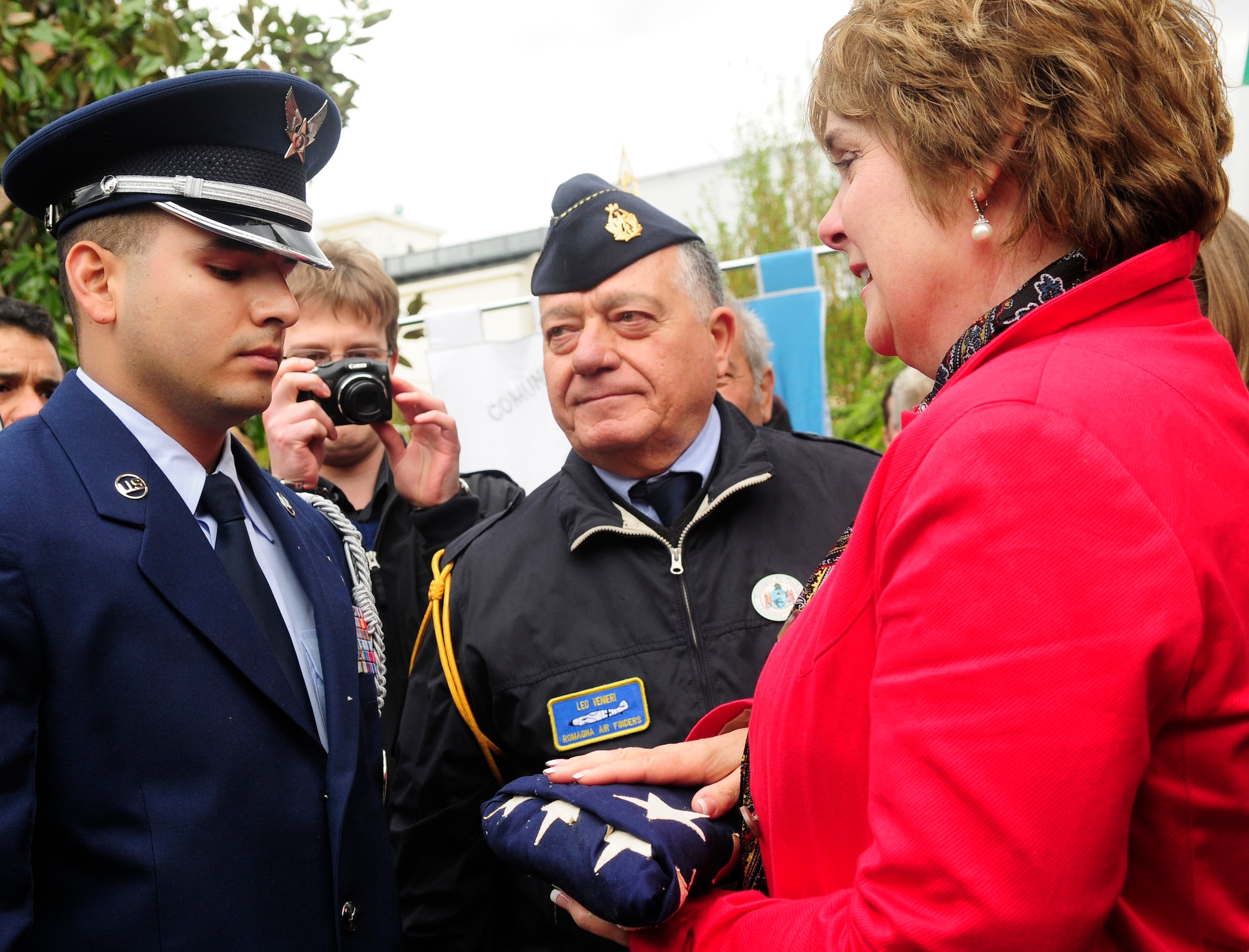 A member of the Aviano Air Base Honor Guard presents an American Flag to Linda Tagert, niece of Maj. Hugh Muse, Jr., during a remembrance ceremony April 14 at Vighizzolo D’Este, Italy. The remembrance ceremony was held to honor Muse, a World War II pilot who was shot down over Northern Italy on Dec. 25, 1943. (U.S. Air Force photo/Airman 1st Class Briana Jones)