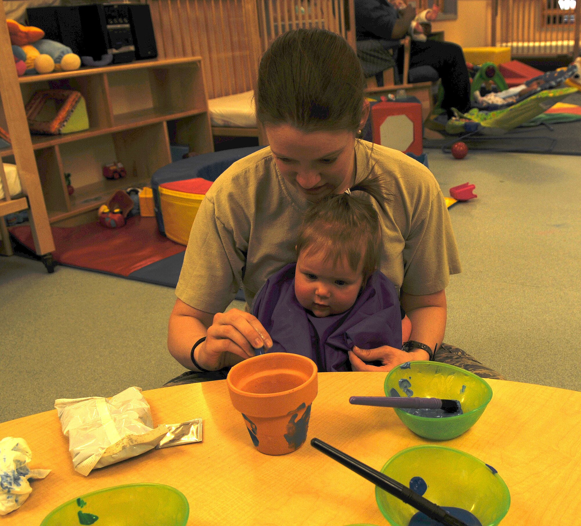 RAF MILDENHALL, England – Staff Sgt. Jaclyn Cravens, 352nd Special Operations Support Squadron, and her daughter, Alyson, paint a pot during an Earth Day parent involvement project at the RAF Mildenhall Child Development Center April 19, 2012. The Cravens planted a basil plant. (U.S. Air Force photo/Senior Airman Rachel Waller)