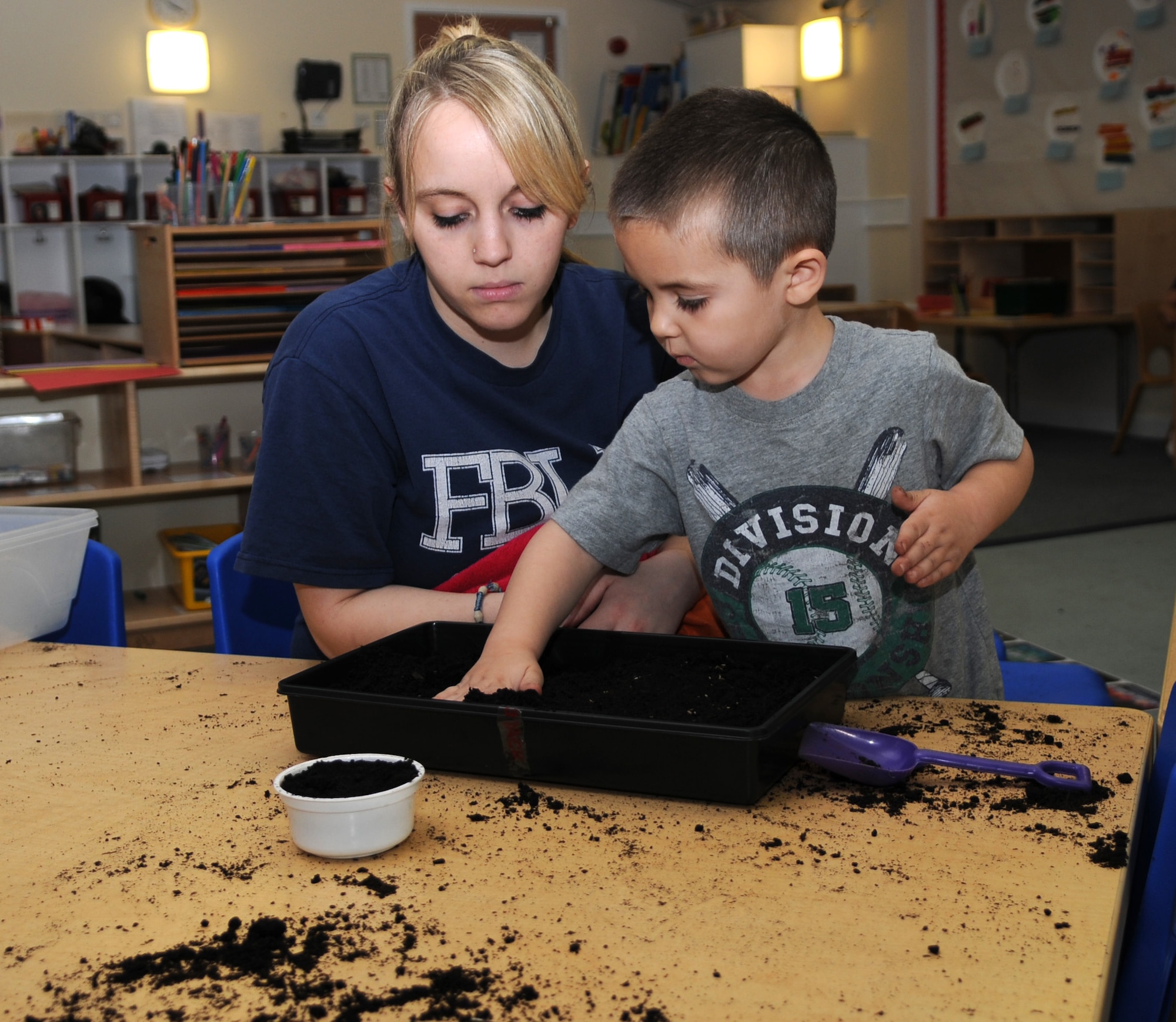 RAF MILDENHALL, England – Braydon Merrill pats down soil over carrot seeds with his mom, Vanessa, during an Earth Day parent involvement project at the RAF Mildenhall Child Development Center April 19, 2012. Parents and their children planted vegetable and herb seeds in pots and planters to celebrate Earth Day. (U.S. Air Force photo/Senior Airman Rachel Waller)