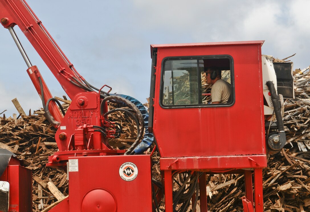 ANDERSEN AIR FORCE BASE, Guam— An Airman from the 36th Civil Engineer Squadron horizontal shop recycles used wood from the sanitary land fill March 20. The wood and debris being recycled is picked up by the base pride detail team that travels throughout Andersen AFB collecting trash and recyclables. (U.S. Air Force photo by Airman 1st Class Mariah Haddenham/Released)