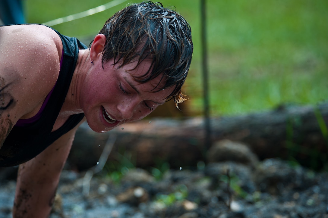 Sgt. Lauren Schoener, Marine Drum & Bugle Corps mellophone section leader, catches her breath as she traverses a mud pit laced with barbed wires during the Civilian Military Combine at Bryce Resort, Va., April 21, 2012. The Combine, a weight lifting competition followed by a mountainous 6-mile obstacle course, was the fourth event in the 2012 Commander's Cup series. Schoener was one of four D&B Marines who competed as a team.