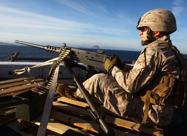 USS NEW YORK - Cpl. Jacob Johnson, an anti-tank missleman with Weapons Company, Battalion Landing Team 1st Battalion, 2nd Marine Regiment, 24th Marine Expeditionary Unit, sits behind an M-2 50 cal. heavy machine gun providing security for the ship as she passes through the Straits of Gibraltar, April 20, 2012. The 24th MEU is currently deployed with the Navy's Iwo Jima Amphibious Ready Group as a theater reserve and crisis response force capable of a variety of missions from full-scale combat operations to humanitarian assistance and disaster relief. (Official Marine Corps Photo by Cpl. Michael Petersheim)