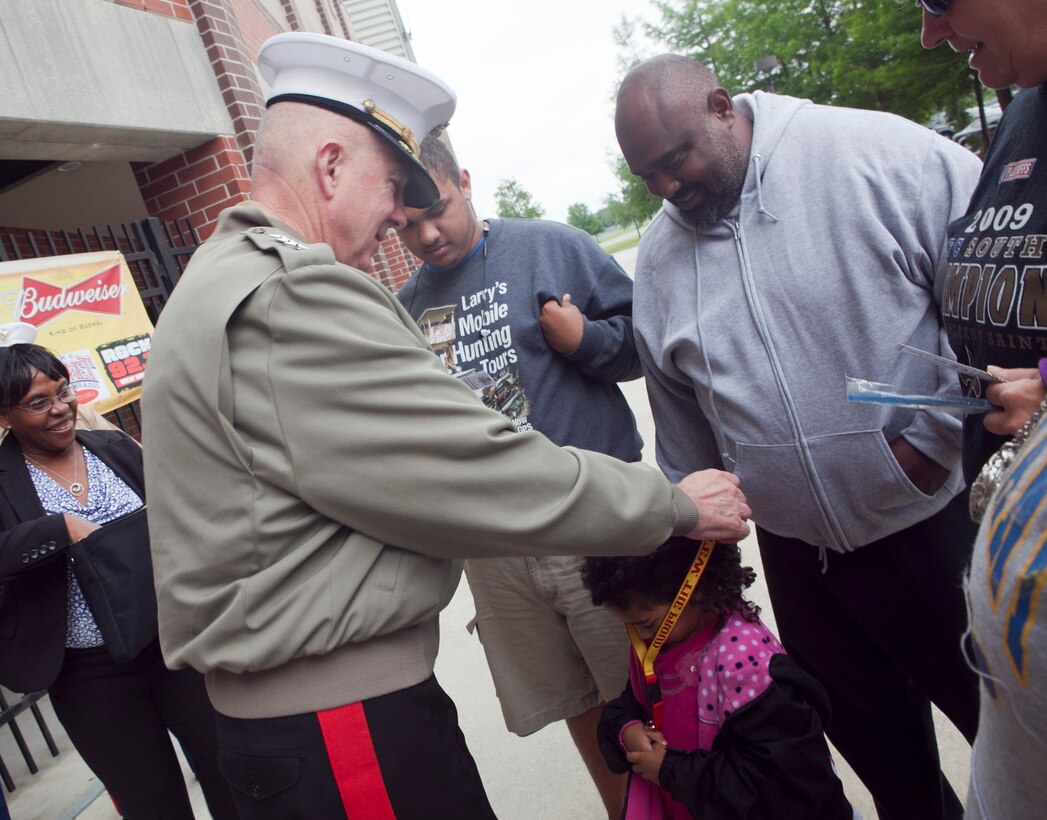 Lt. Gen. Steven A. Hummer, commander of Marine Forces Reserve and Marine Forces North, presents a Marine Corps souvenir to a child at the Zephyrs baseball game, April 21, 2012. The general threw the first pitch at the game as part of the War of 1812 Commemoration. New Orleans will serve as the inaugural city in a three-year national celebration commemorating the War of 1812 and the Star-Spangled Banner. The Marine Corps’ role in this event reinforces its naval character, showcases the Navy-Marine Corps team and highlights the military’s enduring relationship with the city of New Orleans. (U.S. Marine Corps photo by Lance Cpl. Marcin Platek/Released)