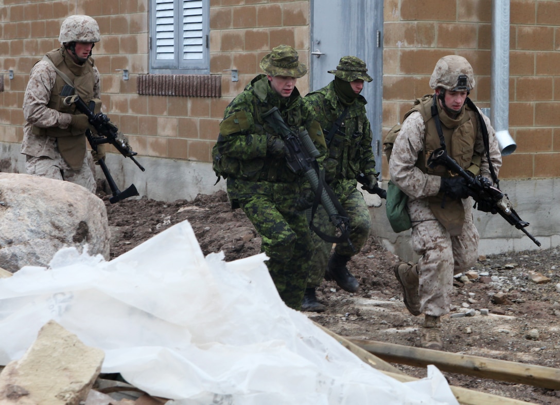 A fire team of Marines from Company I, 3rd Battalion, 25th Marine Regiment, based out of Buffalo, N.Y. and soldiers with the Royal Hamilton Light Infantry, Canadian Forces from Hamilton, Ontario, rush to a series of obstacles during door-breaching training as part of a small scale bilateral exercise with the Canadian military April 20-22. The purpose of the training was to exchange infantry strategies and tactics as well as further enhance relationships and interoperability between the two military components. (Marine Corps Photo by Cpl. Lucas Vega)