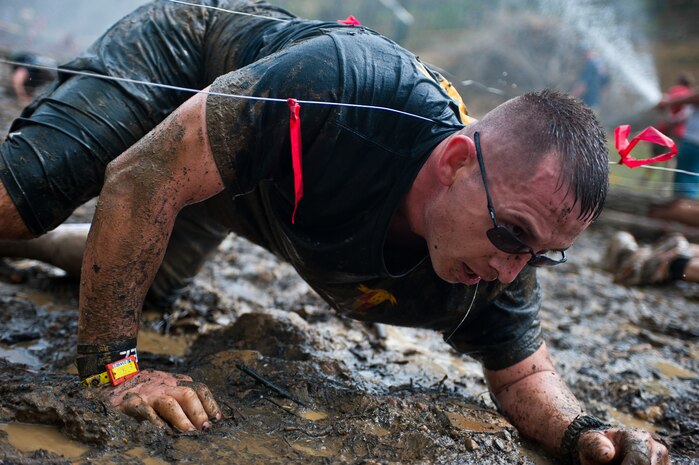 Staff Sgt. Joshua Miles, Marine Drum & Bugle Corps marketing chief, crawls through mud and under wires during the Civilian Military Combine at Bryce Resort, Va., April 21, 2012. The Combine, a weight lifting competition followed by a mountainous 6-mile obstacle course, was the fourth event in the 2012 Commander's Cup series. Miles was one of four D&B Marines who competed as a team.