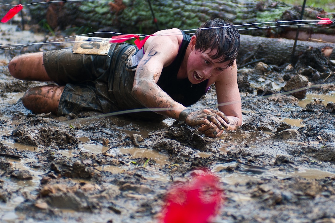 Sgt. Lauren Schoener, Marine Drum & Bugle Corps mellophone section leader, crawls through a mud pit laced with barbed wires during the Civilian Military Combine at Bryce Resort, Va., April 21, 2012. The Combine, a weight lifting competition followed by a mountainous 6-mile obstacle course, was the fourth event in the 2012 Commander's Cup series. Schoener was one of four D&B Marines who competed as a team.