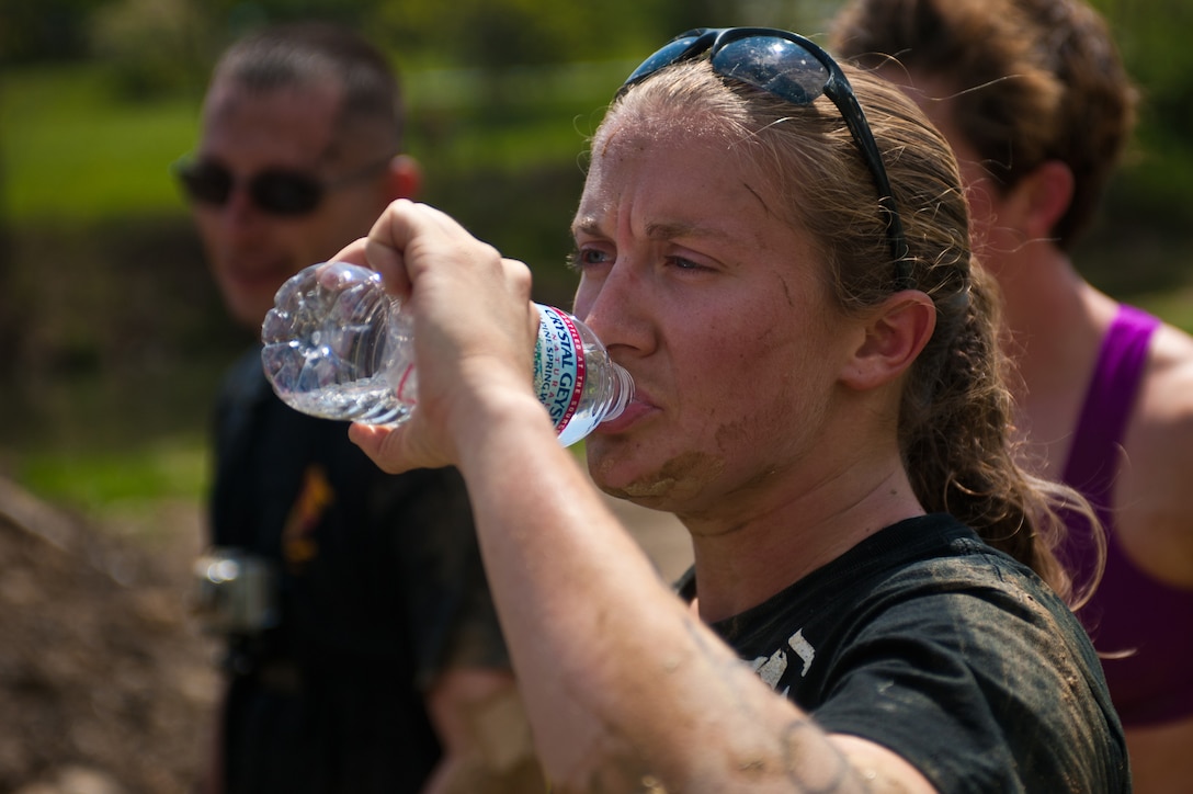 Sgt. Courtney Lawrence, Marine Drum & Bugle Corps marching instructor, rehydrates after finishing the Civilian Military Combine with her team at Bryce Resort, Va., April 21, 2012. The Combine, a weight lifting competition followed by a mountainous 6-mile obstacle course, was the fourth event in the 2012 Commander's Cup series. Lawrence was one of four D&B Marines who competed as a team.