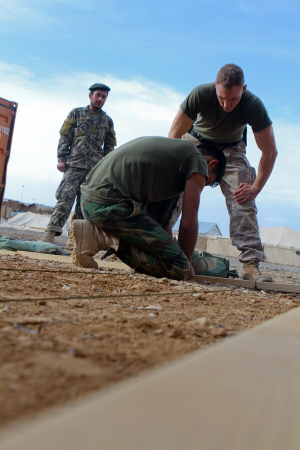 FORWARD OPERATING BASE GERONIMO – Afghan National Army 1st Sgt. Mubarak, the operations first sergeant with 1st Kandak, 1st Brigade, 215th Corps, ties a rope to mark a grid system for a terrain model with Capt. Stephen Walker, the operations advisor with the Embedded Training Team, 2nd Battalion, 6th Marine Regiment, April 21, 2012. Mubarak said he plans on using the model to help brief with future operations. A terrain model is a 3-D map that outlines roads and other major geographical features.