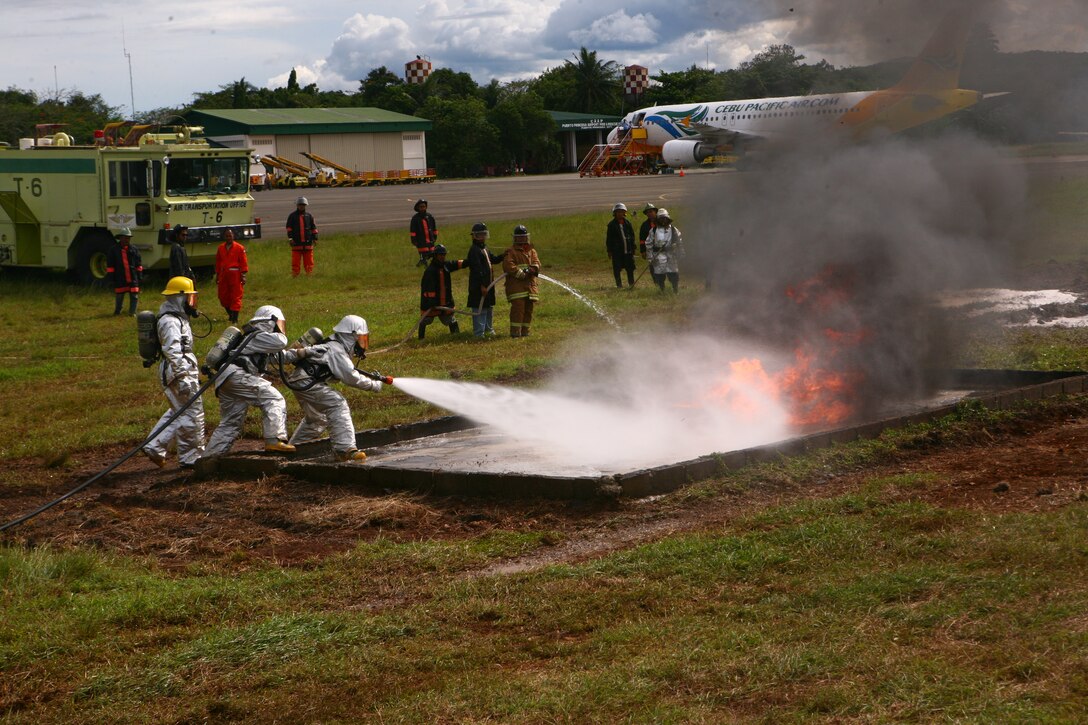 A Puerto Princesa Airport Aircraft Rescue and Fire Fighting team, along with a U.S. Marine ARFF team, put out a training fire on the PPA flight line in Puerto Princesa, Palawan, Republic of the Philippines, April 22, 2012. The fire fighters trained together with U.S. Marines in support of Balikatan 2012 Task Force Palawan. BK12, in its 28th iteration, is a bilateral, joint exercise conducted annually between the Republic of the Philippines and U.S. military members. The U.S. Marines are with Aviation Operations Company, Marine Wing Support Squadron 172, Marine Wing Support Group 17, 1st Marine Aircraft Wing, III Marine Expeditionary Force.