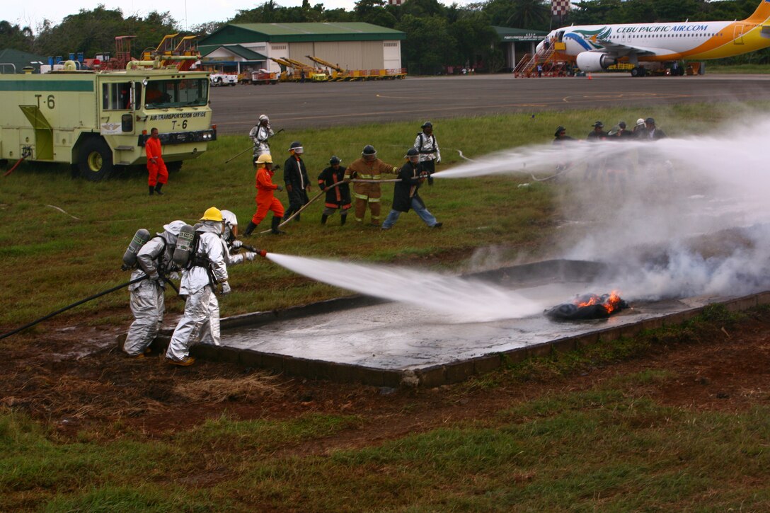 A Puerto Princesa Airport Aircraft Rescue and Fire Fighting team, along with a U.S. Marine ARFF team, put out a training fire on the PPA flight line in Puerto Princesa, Palawan, Republic of the Philippines, April 22, 2012. The fire fighters trained together with U.S. Marines in support of Balikatan 2012 Task Force Palawan. BK12, in its 28th iteration, is a bilateral, joint exercise conducted annually between the Republic of the Philippines and U.S. military members. The U.S. Marines are with Aviation Operations Company, Marine Wing Support Squadron 172, Marine Wing Support Group 17, 1st Marine Aircraft Wing, III Marine Expeditionary Force.