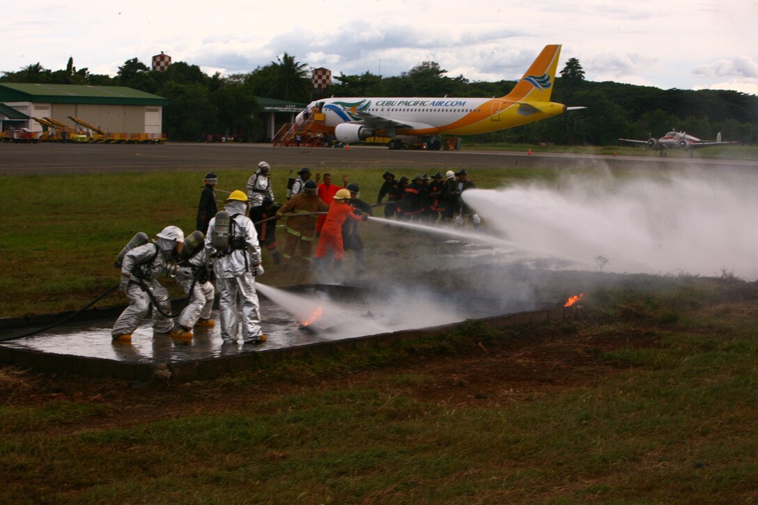 A Puerto Princesa Airport Aircraft Rescue and Fire Fighting team, along with a team of U.S. ARFF Marines, put out a training fire on the Puerto Princesa Airport flight line in Puerto Princesa, Palawan, Republic of the Philippines April 22, 2012. The career counterparts trained with one another during Balikatan 2012 Task Force Palawan. BK12 is a bilateral, joint exercise conducted annually between the U.S. and the Republic of the Philippines. This year marks the 28th iteration of the nations' exercise. The Filipinos are with the PPA. The Marines are with Aviation Operations Company, Marine Wing Support Squadron 172, Marine Wing Support Group 17, 1st Marine Aircraft Wing, III Marine Expeditionary Force.