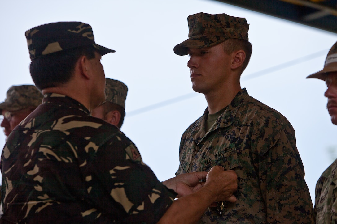 Armed Forces of the Philippines Army Gen. Jessie Dellosa, AFP Chief of Staff, left, pins the Gawad sa Kaunlaran onto Cpl. Michael Masontait, Marine Wing Support Squadron 172, during the dedication ceremony for newly constructed classrooms at Kandis II Elementary School, April 22, 2012. Senior Republic of the Philippines and United States military and government officials attended a Distinguished Visitor's Day as a part of Exercise Balikatan 2012 in Puerto Princesa, Palawan, Republic of the Philippines on April 22, 2012.  The visit included a ribbon cutting ceremony of a new two-room classroom built during an engineering civic assistance project (ENCAP), Philippine and U.S. military field training demonstration and a stopover on the USS Denver.
