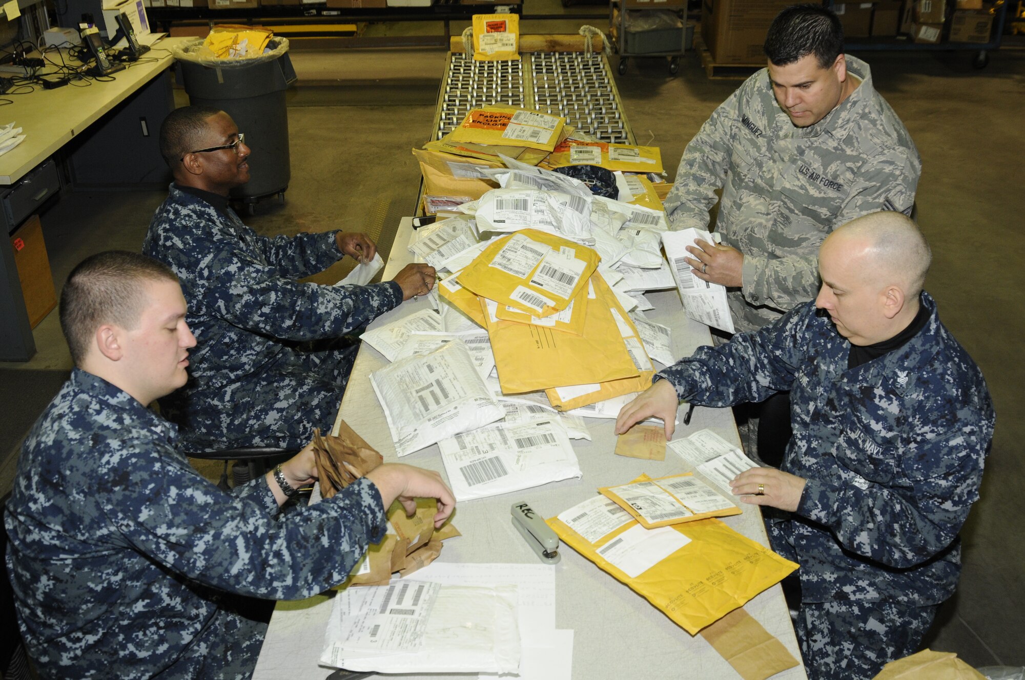 Airmen and Sailors often work closely together in the shipping and receiving area of the 127th Logistics Readiness Squadron at Selfridge Air National Guard Base. Sorting incoming shipments on April 21, 2012, are, from left, LS2 Lawrence Sledz, LS2 Lonnie Wymes, TSgt. James Dominguez and LS1 Charles Rowe. Dominguez is a member of the 127th Wing, Michigan Air National Guard. The Sailors are attached to the Naval Operations Support Center-Detroit, located at Selfridge. (U.S. Air Force photo by TSgt. David Kujawa)