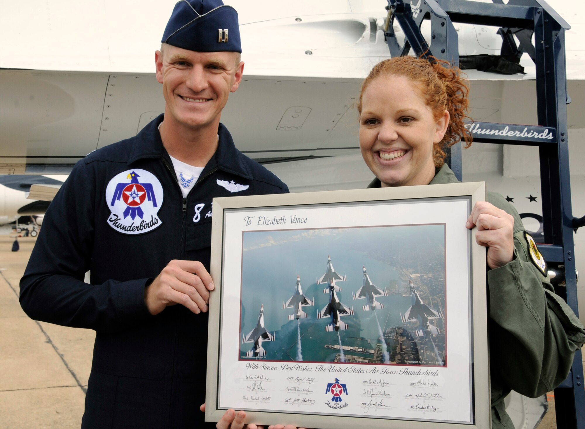 Thunderbirds Pilot Capt. Michael Fisher presents Elizabeth Vance, Cope Middle School 7th Grade science teacher, an autographed aerial team photo on Barksdale Air Force Base, La., April 21. Vance, who received the title of Hometown Hero for being the best middle school teacher in Louisiana, was given the opportunity to fly with a Thunderbirds pilot. (U.S. Air Force photo/Airman 1st Class Benjamin Gonsier)(RELEASED)