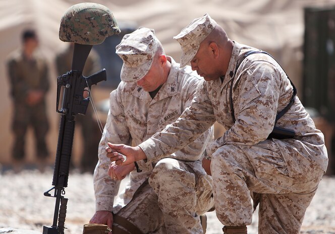 U.S. Marine Col. Roger B. Turner, the commanding officer of Regimental Combat Team 5, and Sgt. Maj. Alberto Ruiz, the RCT-5 sergeant major, observe a moment of silence in respect of Lance Cpl. Abraham Tarwoe, a dog handler and mortarman who served with Weapons Company, 2nd Battalion, 9th Marine Regiment, during a memorial service here, April 22, 2012. Tarwoe was killed in action during a dismounted patrol in support of combat operations in Helmand province’s Marjah district, April 12. Tarwoe’s fellow Marines remember him for his contagious laughter and smile, and his unfaltering courage on the battlefield.