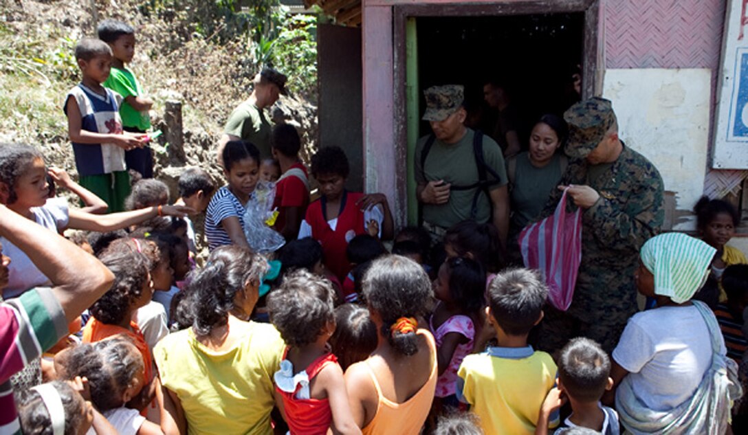 U.S. service members participating in Exercise Balikatan 2012 pass out new shoes to students at a local schoolhouse in the village of Santa Juliana, April 23. Together villagers, Armed Forces of the Philippines and U.S. service members repaired two water pumps, hung tire swings in common areas, renovated the local schoolhouse and donated books and school supplies to children in need during Exercise Balikatan 2012. Balikatan, which means "shoulder to shoulder" in Filipino, is an annual training event aimed at improving combined planning, combat readiness, humanitarian assistance and interoperability between the Armed Forces of the Philippines and United States.