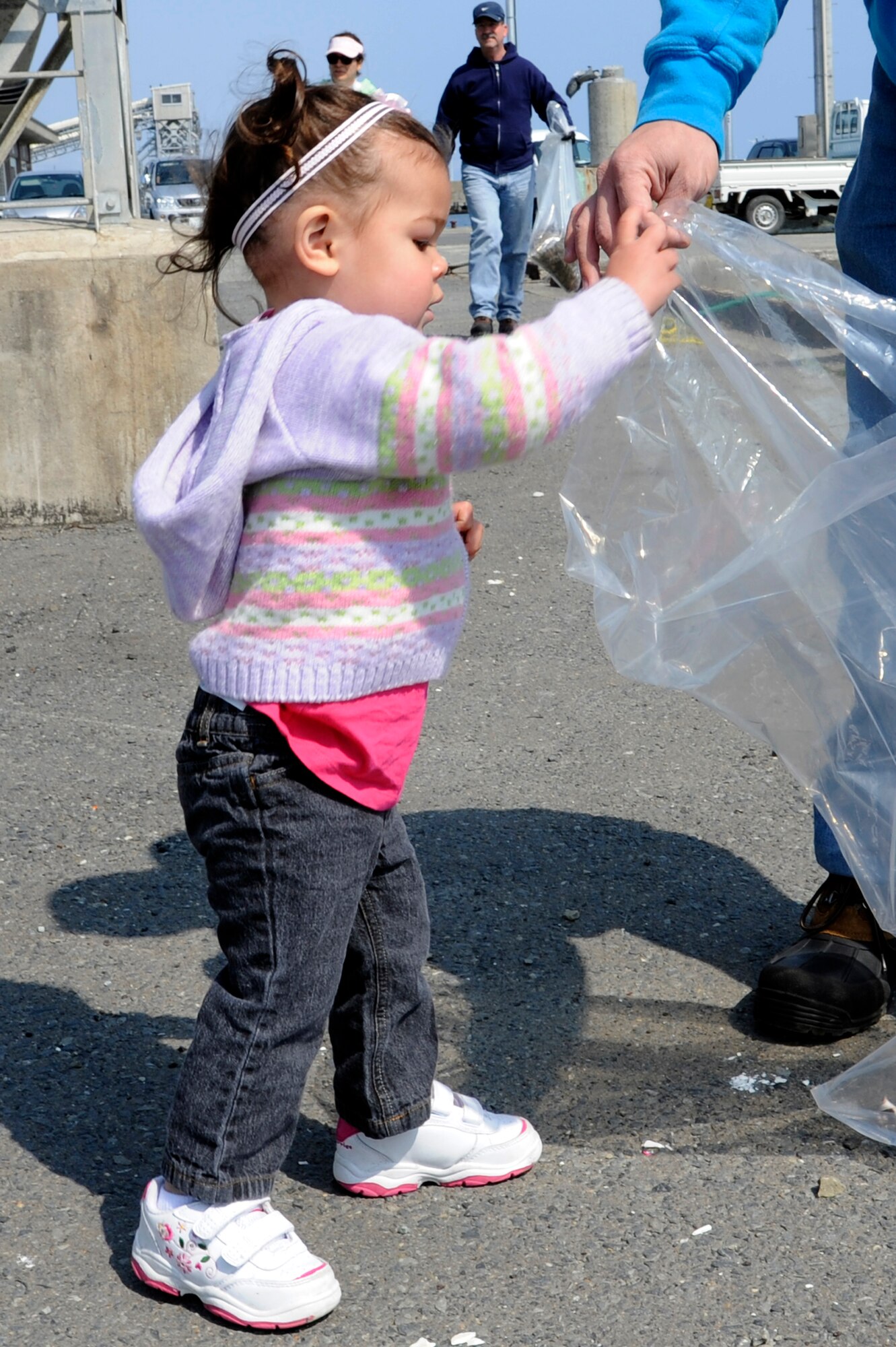 The daughter of U.S. Air Force Tech. Sgt. Marie Brown, 35th Fighter Wing Public Affairs, puts trash into a plastic bag during the 14th Annual Misawa Port Clean-up in Misawa City, Japan, April 21, 2012. The annual event cleared the port of debris and large items that had been washed ashore. (U.S. Air Force photo by Tech. Sgt. Marie Brown/Released)
