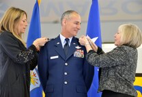 Brig. Gen. Karl McGregor, 452d Air Mobility Wing commander, smiles at his mother-in-law, Jerry Clayman, as she and his wife, Jill, pin stars on his epaulets during the general’s promotion ceremony at March Field, Sat., Apr. 14, 2012. The event, attended by Team March members, community leaders and his friends and family, came two months later because McGregor was deployed during his February promotion. (U.S. Air Force photo by Master Sgt. Linda Welz)