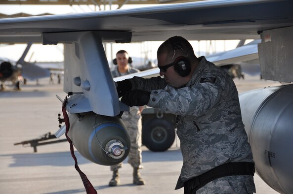 Tech. Sgt. Sean Minnick, 926th Aircraft Maintenance Squadron weapons loader, tightens locknuts on the bomb rack of an F-16 Aggressor aircraft during the quarterly weapons load competition April 6 at Nellis Air Force Base, Nev. (U.S. Air Force photo/Maj. Jessica Martin)