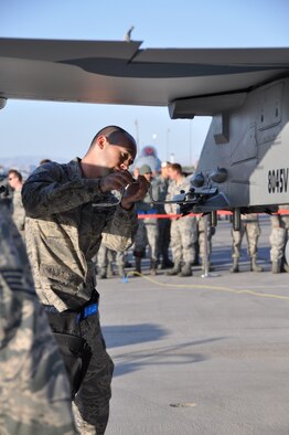 Tech. Sgt. Colin Cave, 926th Aircraft Maintenance Squadron weapons loader, installs impulse cartridges on an F-16 Aggressor aircraft during the quarterly weapons load competition April 6 at Nellis Air Force Base, Nev. (U.S. Air Force photo/Maj. Jessica Martin)