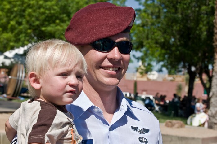 U.S. Air Force Senior Airman Jackson Rogers, 58th Rescue Squadron pararescueman, watches the parade with his son, Eli, age 1, during the Henderson Heritage Parade & Festival April 21, 2012, in Henderson, Nev. Airman Rogers is one of the five Airmen who participated in the parade as a grand marshal. (U.S. Air Force photo by Airman 1st Class Matthew Lancaster)