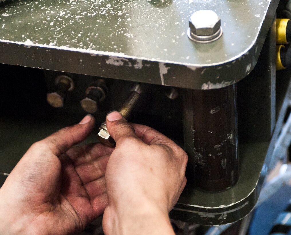 Senior Airman Jacob Hoffman, 28th Maintenance Squadron aerospace ground equipment technician, removes bolts from a mechanical rammer during routine maintenance at Ellsworth Air Force Base, S.D., April 18, 2012. The mechanical rammer is a vital piece which allows munitions to be loaded on the B-1 bomber. (U.S. Air Force photo by Airman 1st Class Alystria Maurer/Released)