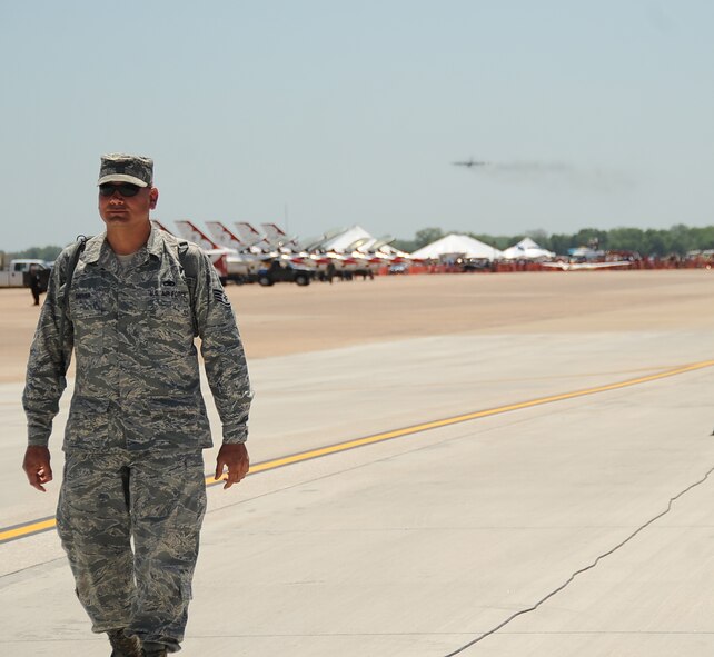 Staff Sgt. Jeffrey Driver, 2nd Maintenance Squadron, helps secure the base flightline as a B-52H Stratofortress prepares to pass the viewing area during the 2012 Barksdale Air Force Base Defenders of Liberty Air Show April 22. Airmen from more than 15 base agencies participated in the annual air show, providing security details, stand-by emergency responders and booth volunteers. (U.S. Air Force photo/Staff Sgt. Amber Ashcraft) (RELEASED)